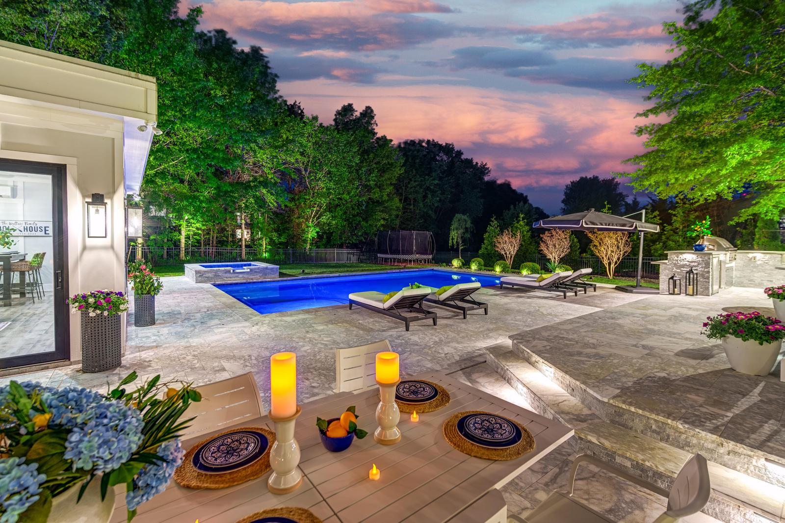 Candlelit table setting in the foreground, pool beyond